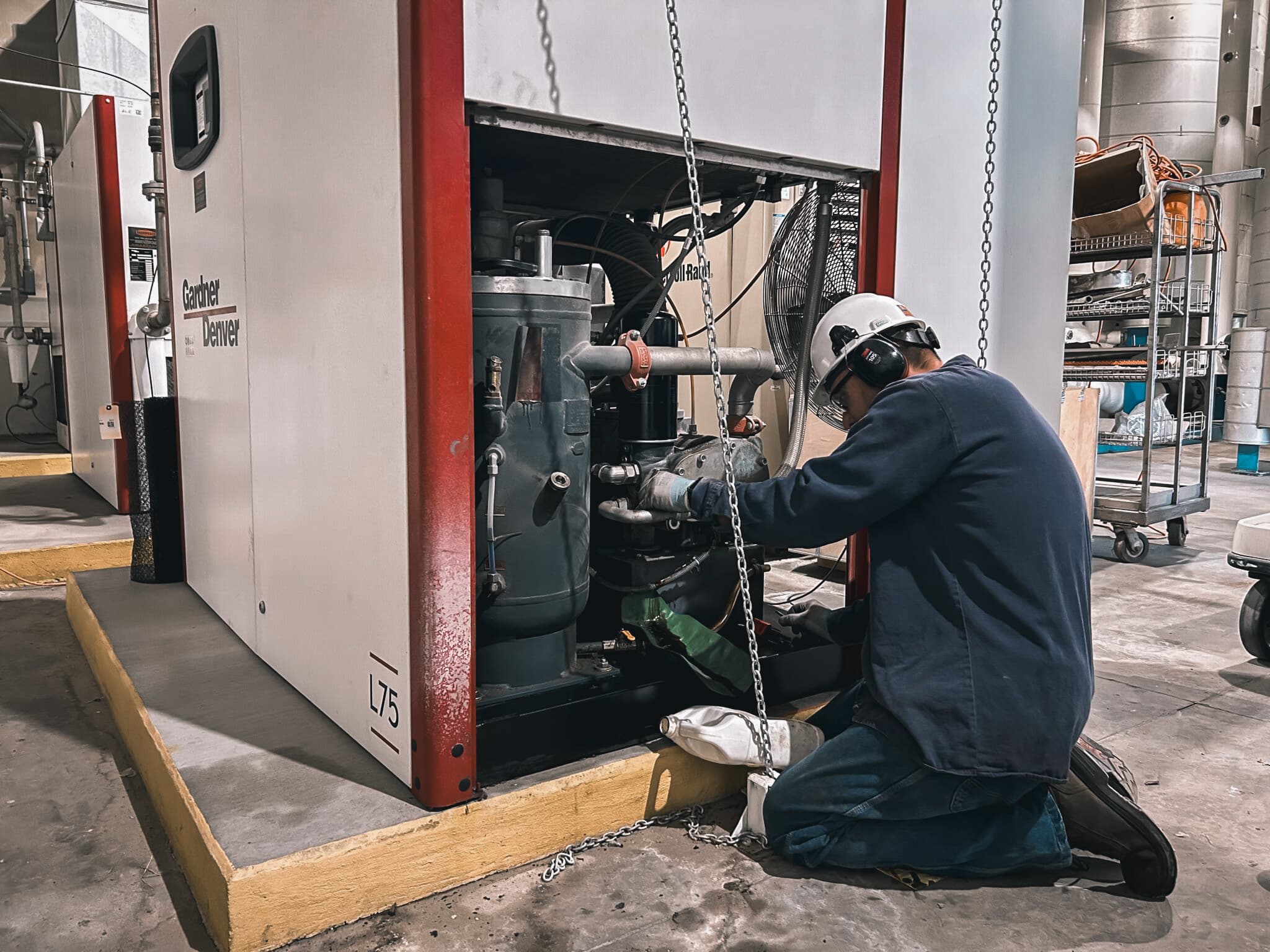Technician servicing industrial compressed-air equipment